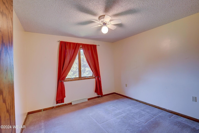 spare room featuring carpet flooring, a textured ceiling, and ceiling fan