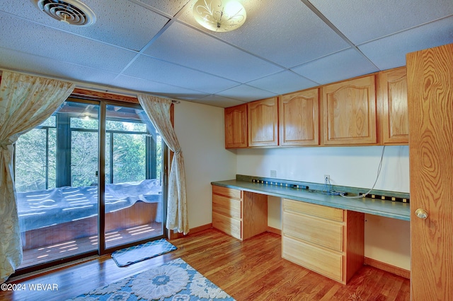 kitchen featuring light brown cabinets, a paneled ceiling, and light hardwood / wood-style flooring