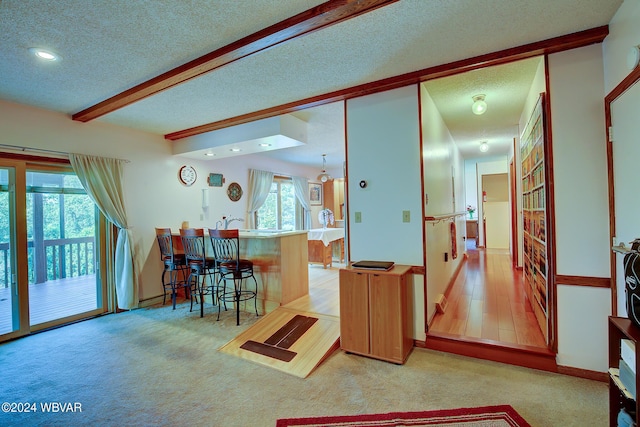 kitchen with a kitchen bar, a textured ceiling, and plenty of natural light