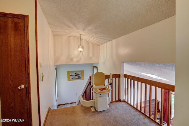 corridor with carpet floors and a textured ceiling