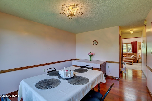 dining room featuring a textured ceiling and light hardwood / wood-style flooring