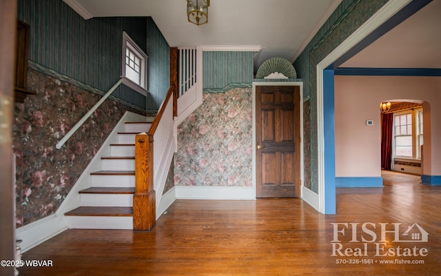 stairway featuring hardwood / wood-style flooring, a notable chandelier, and crown molding