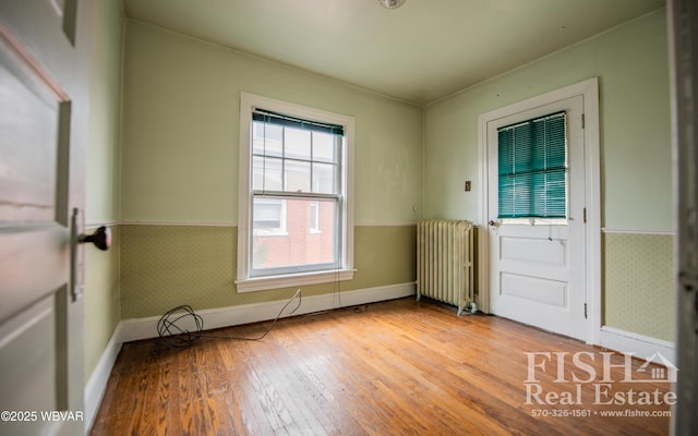 entrance foyer with radiator heating unit and light hardwood / wood-style flooring