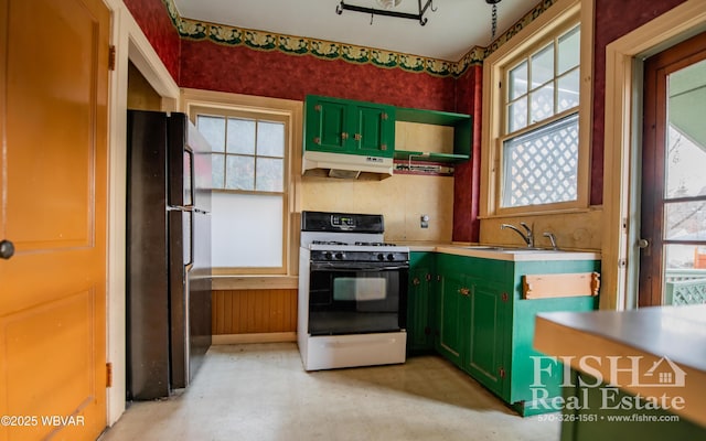 kitchen with a wealth of natural light, black fridge, green cabinets, and range with gas cooktop