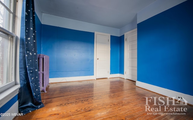 spare room with hardwood / wood-style flooring and a wealth of natural light