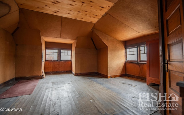 bonus room featuring wood walls, lofted ceiling, wood ceiling, and light hardwood / wood-style flooring