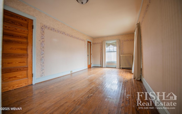 unfurnished room with radiator and hardwood / wood-style floors