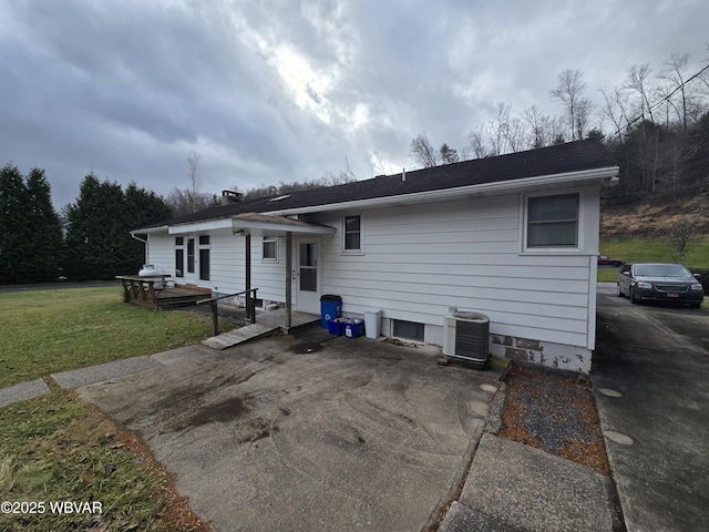 view of front facade featuring cooling unit, a patio, and a front lawn