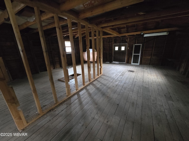 misc room with plenty of natural light, wood finished floors, and heating fuel