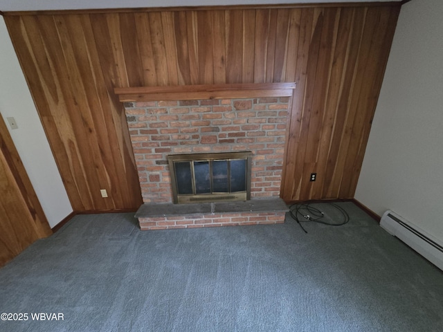 unfurnished living room with a baseboard radiator, dark colored carpet, a brick fireplace, wood walls, and baseboards