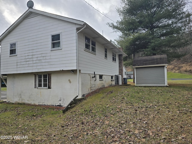 view of side of property with a storage shed and a lawn