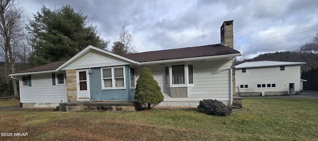 rear view of house with a lawn and a chimney