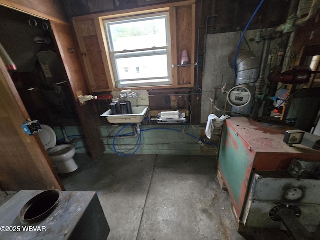 bathroom with toilet, sink, and concrete floors