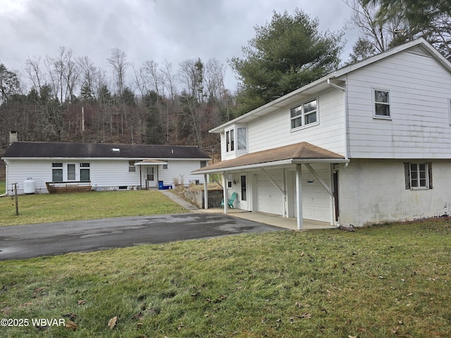 rear view of house featuring a yard and a garage