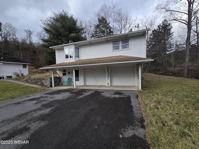 view of property featuring a garage and a front lawn