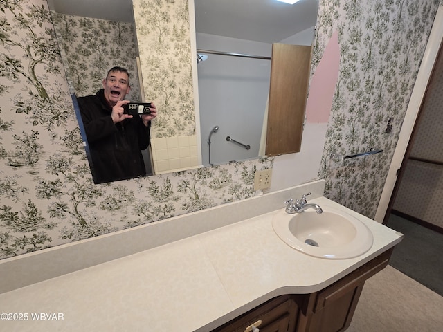 bathroom with wallpapered walls and vanity