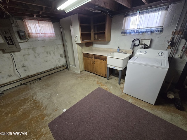 below grade area with a healthy amount of sunlight, washer / dryer, electric panel, and a sink