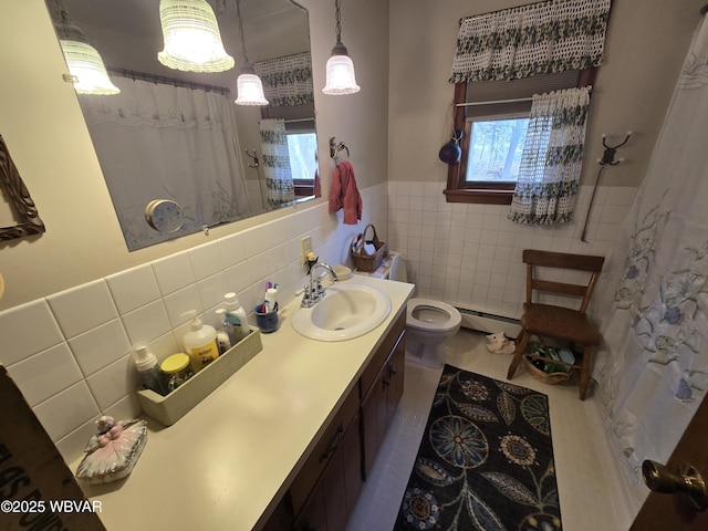 bathroom with tile patterned flooring, plenty of natural light, tile walls, and a baseboard radiator