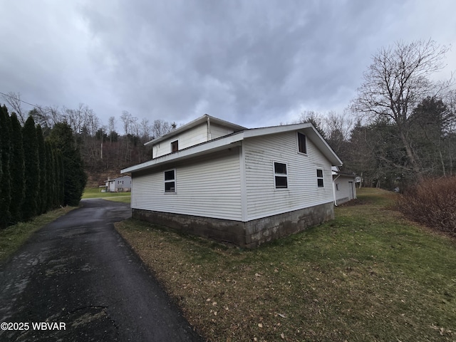 view of side of property featuring a yard and driveway