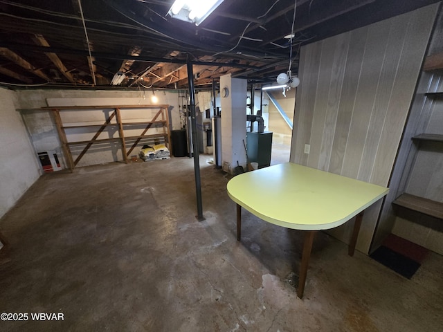 unfinished basement featuring stairway and heating unit