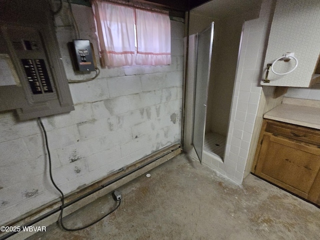 bathroom with vanity, a shower stall, electric panel, and concrete block wall