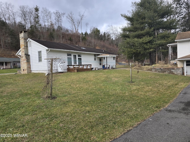 view of front of home featuring a front yard and a chimney