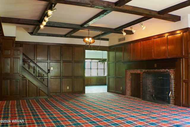 unfurnished living room with carpet, beam ceiling, and rail lighting