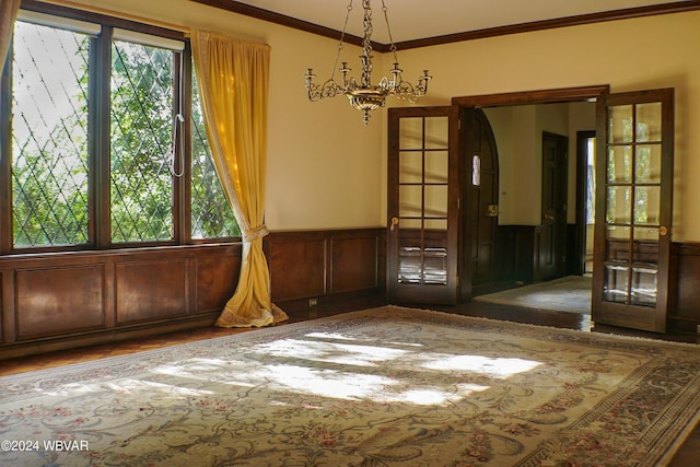 empty room with french doors, plenty of natural light, and crown molding