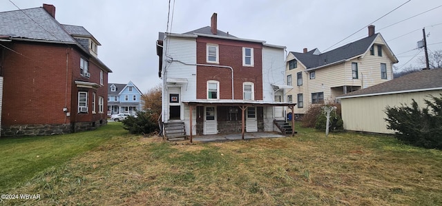 rear view of property with a yard