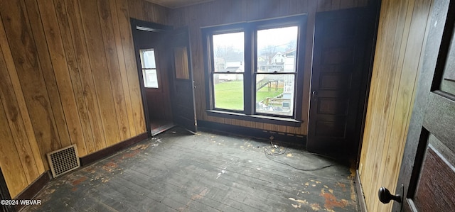 spare room featuring wooden walls and dark hardwood / wood-style floors