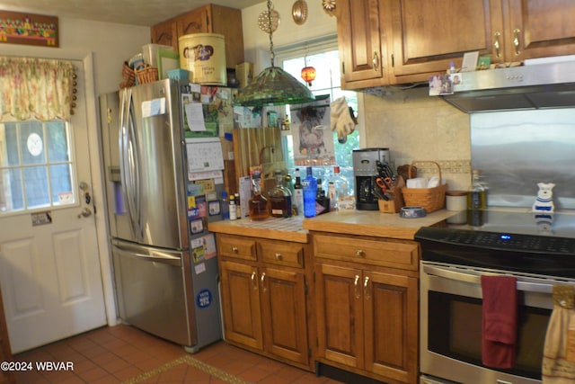 kitchen featuring backsplash, light tile patterned floors, range hood, and appliances with stainless steel finishes