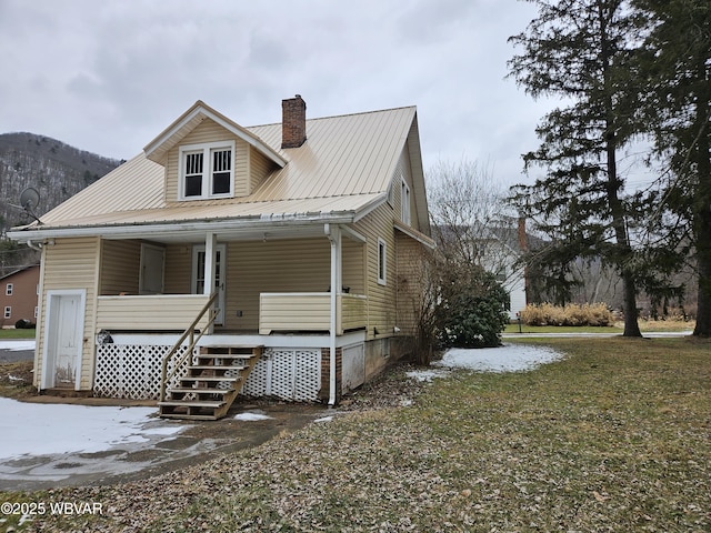 view of front of house with covered porch, a mountain view, and a front lawn