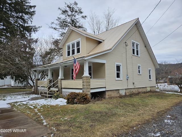 view of front of property with covered porch and a lawn