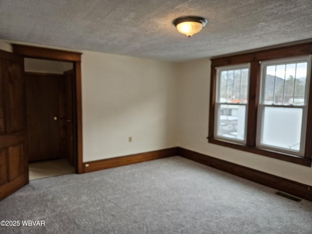 unfurnished room with light carpet and a textured ceiling