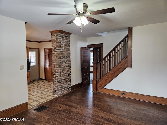 foyer featuring ornate columns, crown molding, dark hardwood / wood-style flooring, and ceiling fan