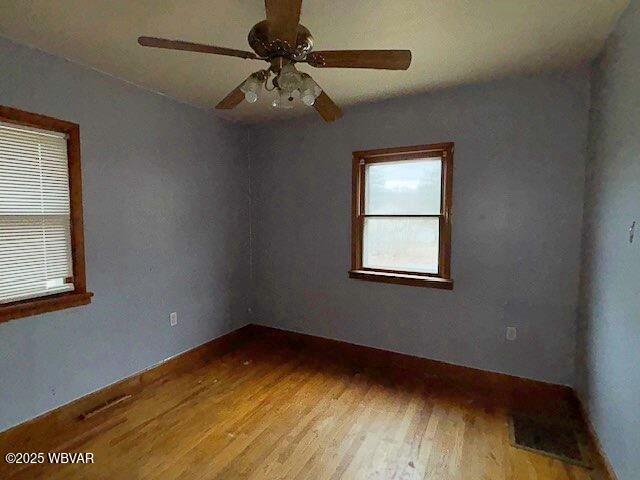 unfurnished room featuring wood finished floors and a ceiling fan