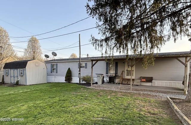 rear view of property with a patio area, an outbuilding, a yard, and a shed