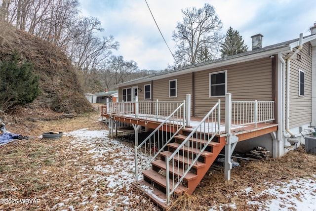 snow covered house featuring a wooden deck