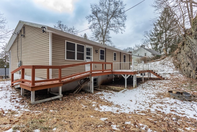 snow covered property with a deck