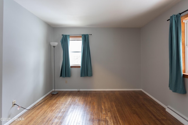 empty room with hardwood / wood-style floors and a baseboard radiator