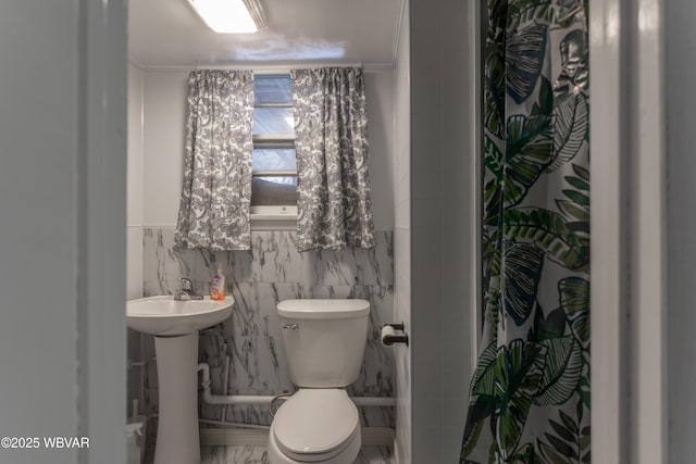 bathroom with toilet, tile walls, ornamental molding, and curtained shower