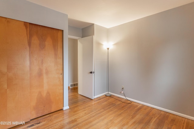 unfurnished bedroom featuring a closet and light hardwood / wood-style floors