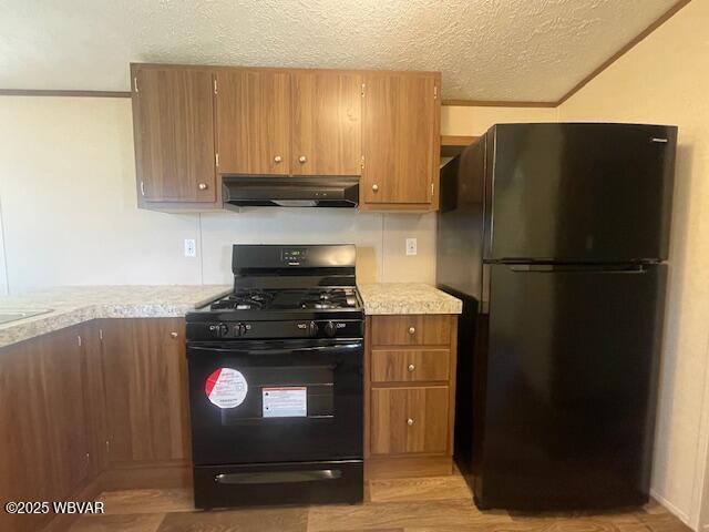 14 Albatross Dr, Watsontown, PA 17777 - kitchen featuring black appliances, under cabinet range hood, light countertops, a textured ceiling, and brown cabinets