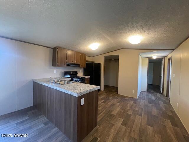 14 Albatross Dr, Watsontown, PA 17777 - kitchen with stove, a textured ceiling, light countertops, under cabinet range hood, and a peninsula