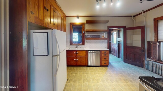 kitchen featuring dishwasher, backsplash, sink, ornamental molding, and white fridge