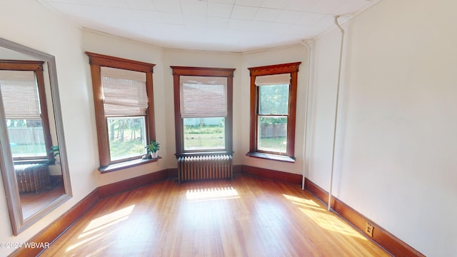 empty room featuring radiator and light hardwood / wood-style floors