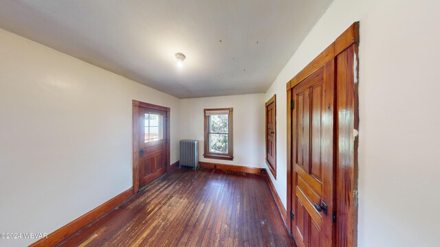 interior space featuring radiator heating unit and dark hardwood / wood-style flooring