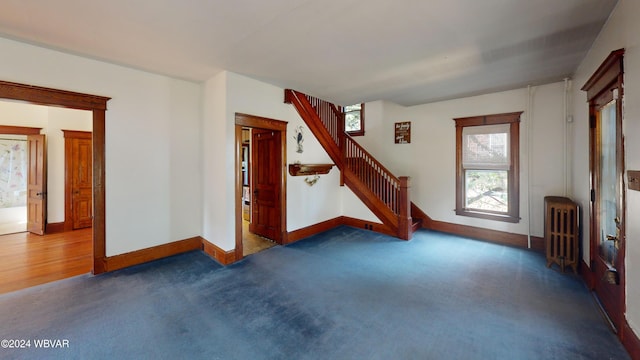 interior space featuring radiator and dark colored carpet