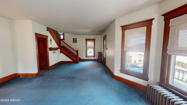 interior space featuring dark colored carpet and radiator