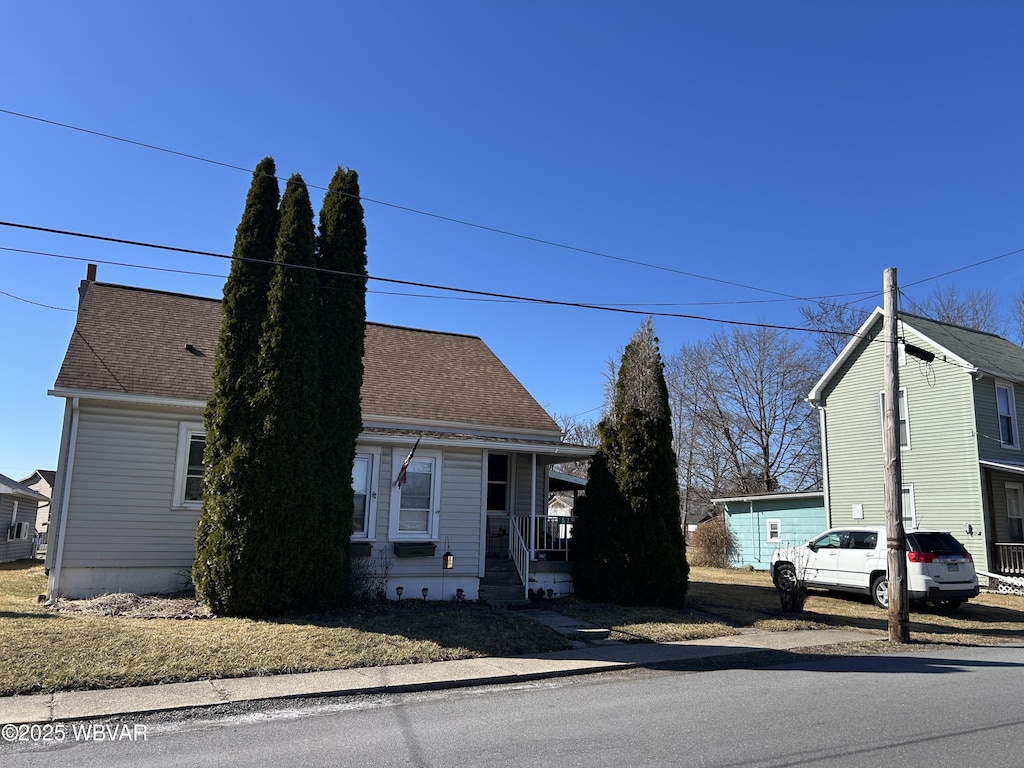 view of front of house with covered porch and a shingled roof